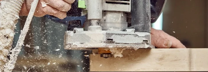 Person fräst Holz mit Oberfräse